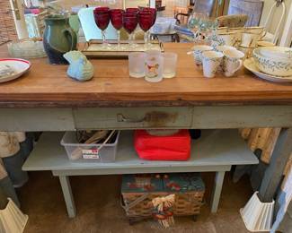 This is a great piece:  metal work table with single drawer with wood top.  She had a custom skirt made and as you can see, it is sitting on risers