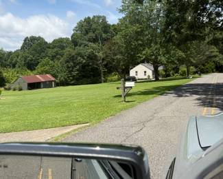 This is the front of the house, if the house is on your left. Only parking in front of the house but not on the grass and not blocking the mailbox. You'd have to park halfway on the grass because this is a main road and the other side of the road is a ditch. 
