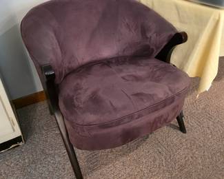 purple accent chair features a curved barrel back and tapered dark wood legs