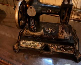 antique Muller Model 19 German cast iron sewing machine features intricate floral decals and a hand crank