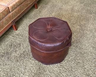 vintage brown pouf ottoman, likely from the 1970s, features distinctive flower-shaped stitched detailing on the top.