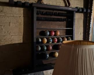antique or vintage wooden pool ball rack, often featuring a dark stain and designed to mount on a wall.