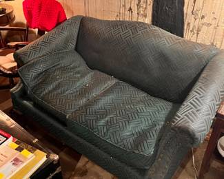 vintage loveseat features dark green upholstery with a textured geometric pattern.