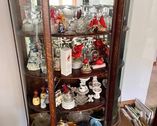 antique curved glass curio cabinet features a mahogany finish, three shelves, and a mirrored back for displaying collectibles