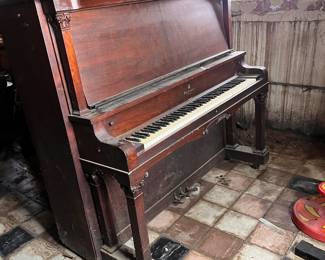 20th-century antique upright piano featuring a dark wood finish and potential ivory keys