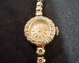 Vintage 1954 Ladies Rolex Watch with Mother of Pearl Clock Face surrounded by 18 Diamonds, a 1400 Watch Movement and a 14K Tennis Bracelet Watch Band Encrusted with 44 Diamonds Total Carat Weight of Diamonds is 5.3k (it is missing one .10 diamond on the watch band) Serial number of the Rolex is 63686.