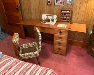 Vintage sewing machine in cabinet with storage chair. 