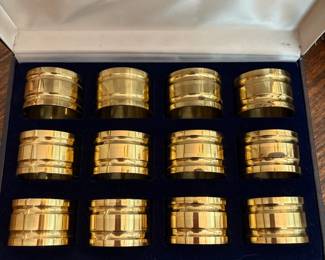 R62 - $20. Set of 12 Brass Napkin Rings in Box. Shows some minor wear.