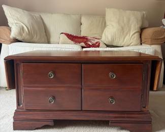 R4 - $50. Drop Leaf Coffee Table. Measures 35" wide x 24" deep x 18" tall. Very good condition! The front is doors (not drawers) the back pulls out for magazine storage.