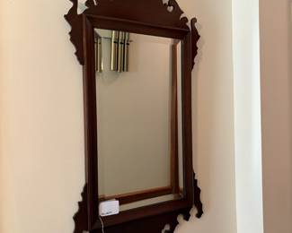 R51 - $125. Mahogany Chippendale-style Hanging Wall Mirror. Possibly unmarked Craftique. Feature a decorative scroll-cut pediment. Beveled Glass. Measures 19" wide x 33.5" tall.