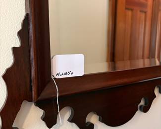 R51 - $125. Mahogany Chippendale-style Hanging Wall Mirror. Possibly unmarked Craftique. Feature a decorative scroll-cut pediment. Beveled Glass. Measures 19" wide x 33.5" tall.