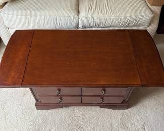 R4 - $50. Drop Leaf Coffee Table. Measures 35" wide x 24" deep x 18" tall. Very good condition! The front is doors (not drawers) the back pulls out for magazine storage.