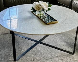 This Room & Board Classic Round Coffee Table features a polished white marble top supported by a black steel base.