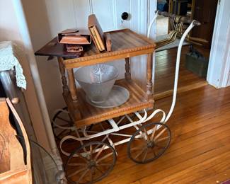 Antique baby carriage frame that’s been converted into a tea  cart 