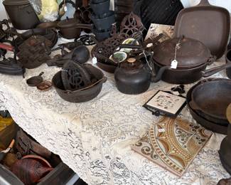 A large assortment of. Cast iron pots and trivets 