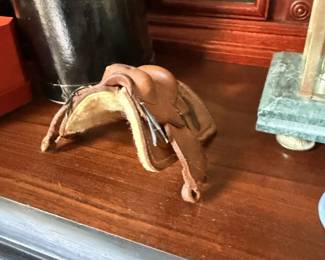 Horse figure or sculpture on black tabletop in front of mantel clock.