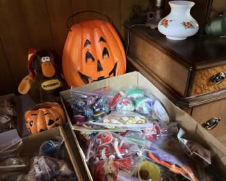 Halloween and toy box lot with pumpkin bucket, plush monkey and assorted small toys.