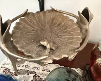 Pressed-glass leaf dish or flower-shaped bowl with metal stand behind.