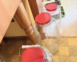 Assorted glass jars with red lids and clear storage jars.