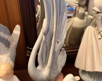 White and blue ceramic swan pair with flowing wing forms.