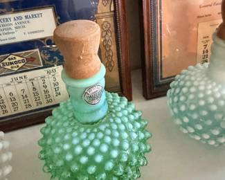 Green hobnail perfume bottle or atomizer with stopper and other vanity bottles.