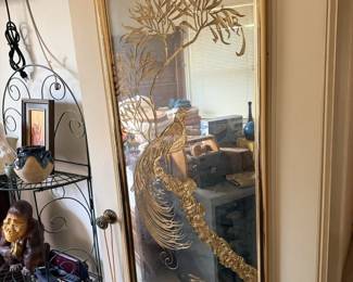 Large wall mirror with metal bird or peacock-style wall decor and hanging rack.