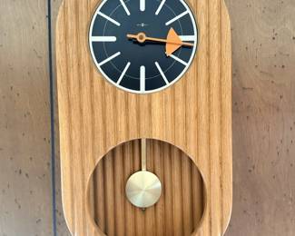 Kienzle German mid-century wood pendulum wall clock with black dial, orange hand and brass pendulum.