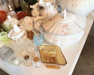 Large white wash pitcher or basin-style piece with glass and small decor around it.