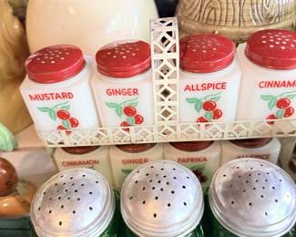 Spice tins and boxes including mustard, ginger, allspice and cinnamon, plus green shakers and kitchen canisters.
