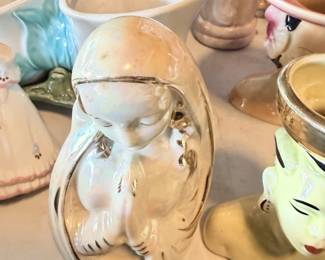 Close-up of figural pottery vase or planter with face/detail.