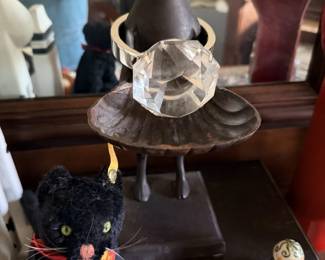 Black cat figure with clear crystal/tutu-style dress on stand plus small black cat at base.