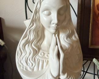 White bust or figure of woman with long flowing hair.