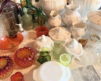 White pitcher, clear glass, red/amber thumbprint bowls and mixed serving ware.