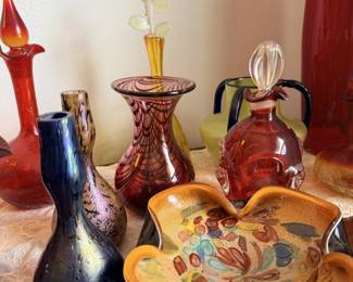 Mixed art glass and pottery vases, including blue, red, amber and orange pieces.