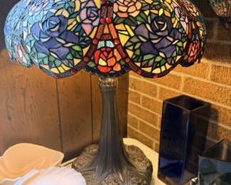 Tiffany-style rose and dragonfly stained-glass table lamp with sculpted metal base.