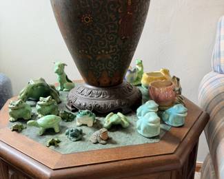 Large brown raku-style patterned floor vase with small green animal figures around base.