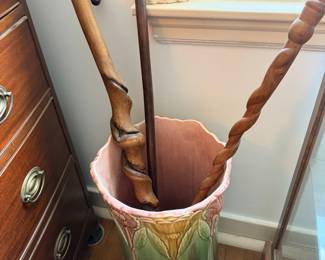 Close-up of glazed umbrella stand with canes and walking sticks.