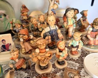 Large table grouping of Hummel-style children figurines and character figures.