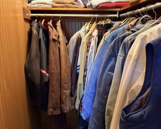 Closet of clothing, jackets, shirts and hanging garments.