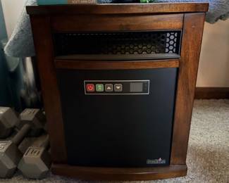 Small dark wood electric heater/fireplace-style cabinet with front vent and control panel.