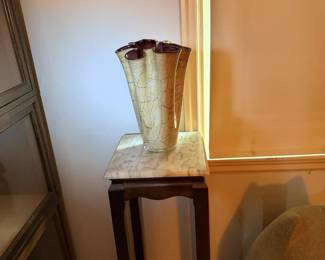 Side table with tall vase and lighted corner display.