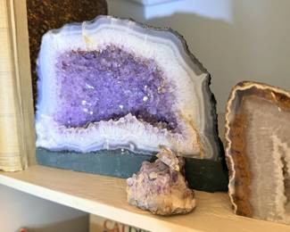 Large amethyst geode with agate and natural mineral display pieces.