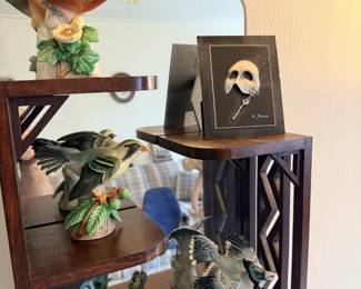 Tiered shelf with bird figure, small framed picture, boxes and decorative collectibles.