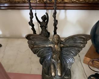 Metal butterfly or fairy figure with wings and rustic bronze-tone finish.