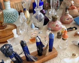 Blue glass bottles and small perfume bottles displayed with decorative figures.