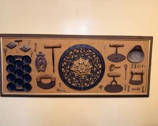 Large framed vintage kitchen/ironwork shadowbox with antique-style keys, trivets, horseshoe, utensils and cast metal medallion.