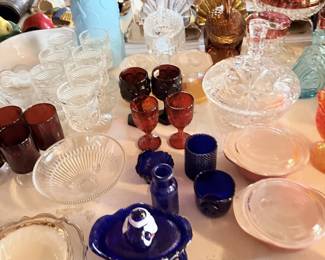 Pressed glass, amber, blue and clear serving pieces across tabletop.