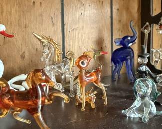 Glass animal grouping with deer, horse and other clear/amber figures.