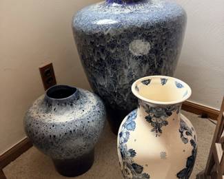 Grouping of blue and white ceramic vases with darker speckled pottery vases.