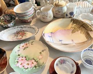 China table with floral plates, teacups, bowls and delicate serving pieces.